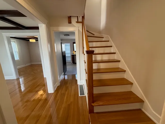 a view of a hallway with wooden floor and entryway