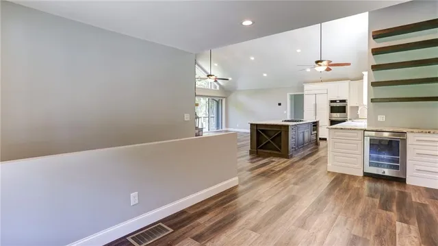 a kitchen with stainless steel appliances granite countertop a stove and a wooden floor
