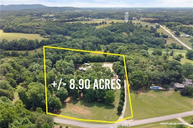 a view of kitchen and empty room with wooden floor