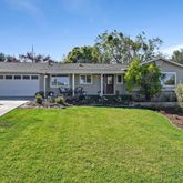 a house view with swimming pool and garden space