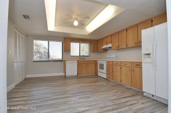 a kitchen with wooden floors and white appliances
