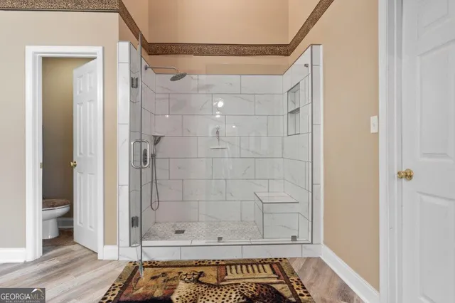 a kitchen with stainless steel appliances granite countertop a refrigerator a sink dishwasher a stove and white countertops with wooden floor