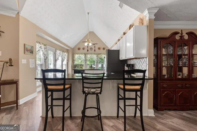 a dining room with furniture a large window and potted plants