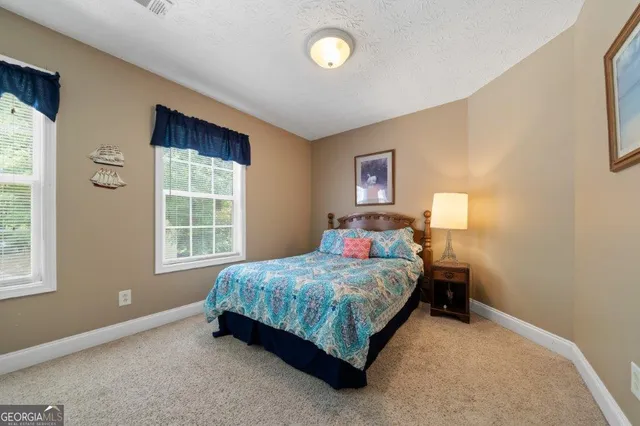 a view of a yard in front of a house with a large tree