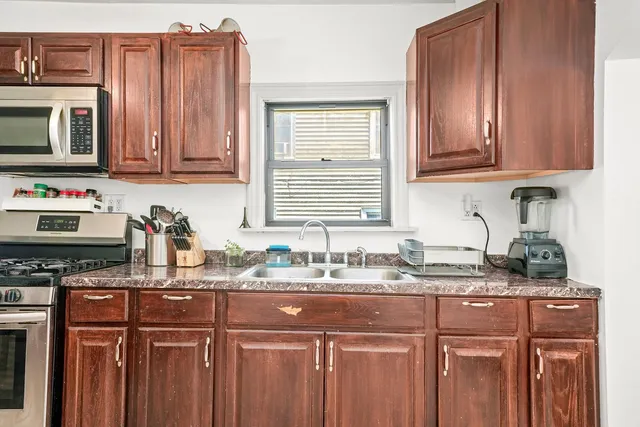 a kitchen with stainless steel appliances granite countertop a sink stove and cabinets