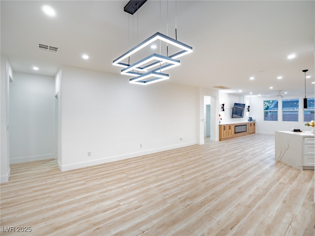 7870 Midnight Ride Street Las Vegas, NV 89131 - Photo 16 of 69 Unfurnished living room featuring recessed lighting, light wood-style flooring, and a chandelier