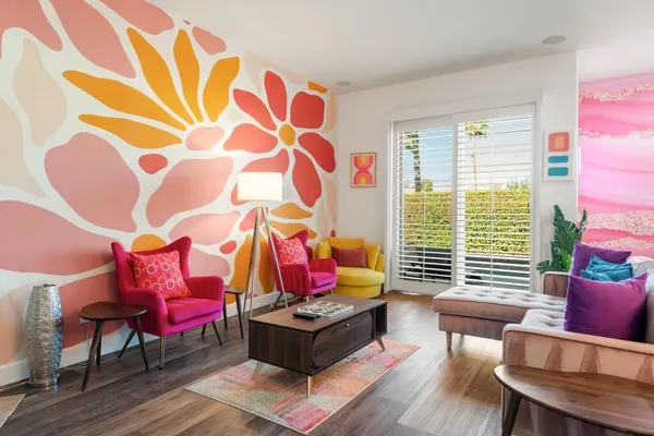 a living room with patio furniture and a floor to ceiling window