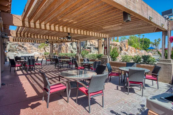 a view of a chairs and table in patio with a barbeque