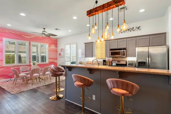 a kitchen with granite countertop a stove a sink and a refrigerator