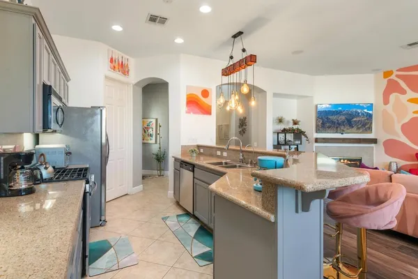 a kitchen with stainless steel appliances granite countertop a sink and a refrigerator