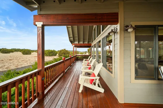 a view of a balcony with chairs and wooden floor