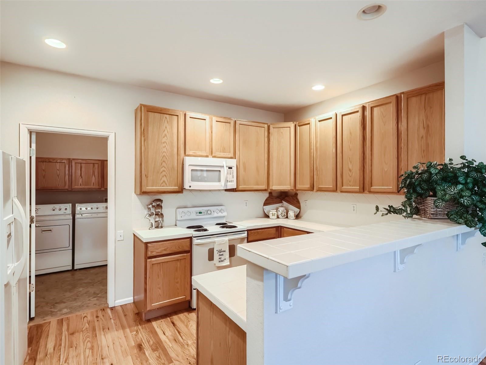 6224 Secrest Street Arvada, CO 80403 - Photo 4 of 16 a kitchen with a sink cabinets and wooden floor