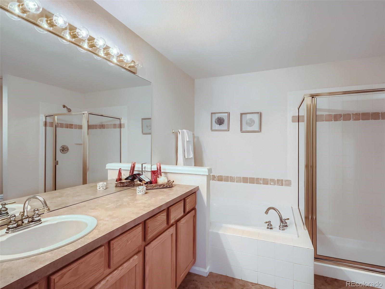 6224 Secrest Street Arvada, CO 80403 - Photo 7 of 16 a bathroom with a tub a double vanity sink and mirror