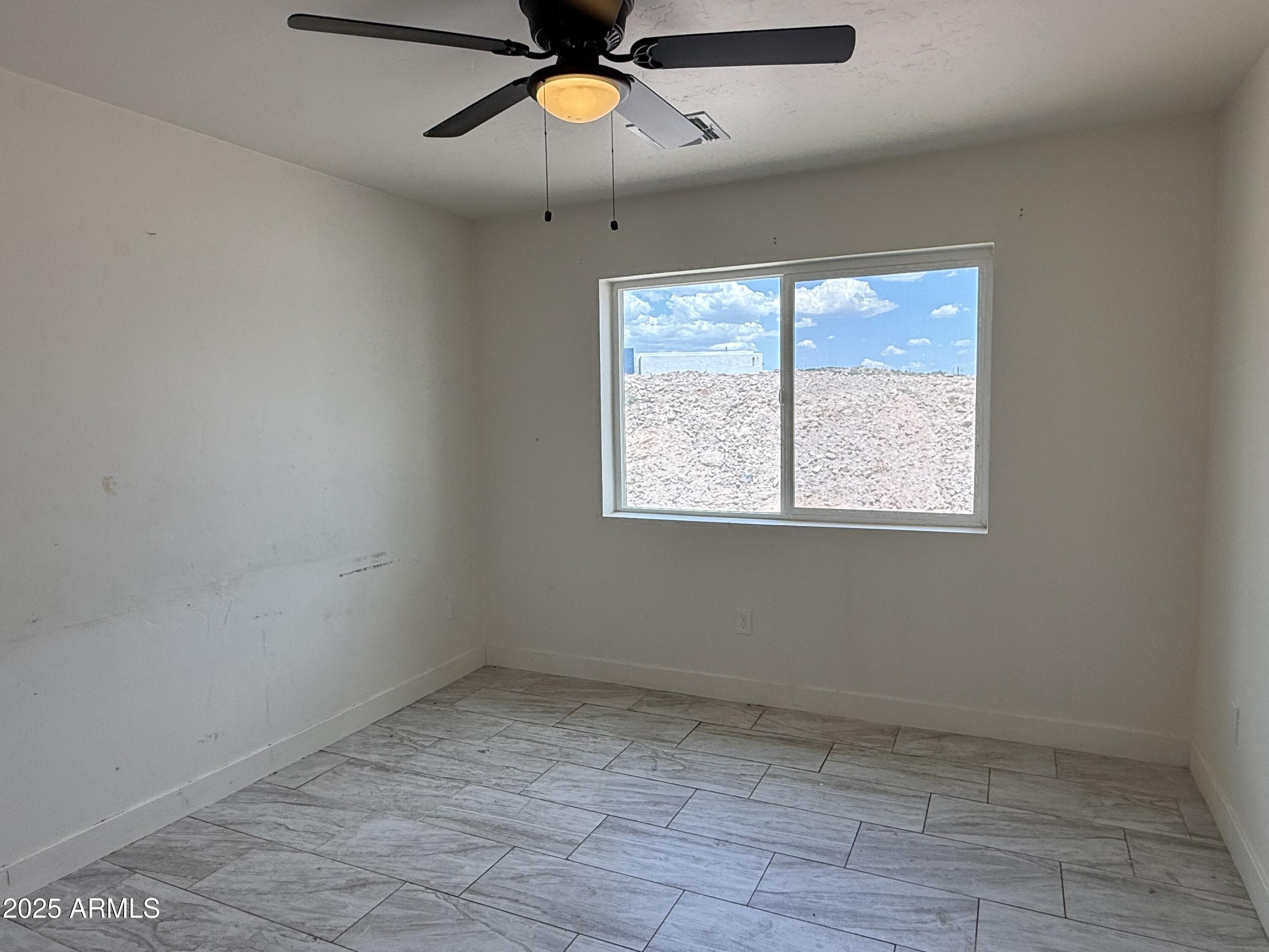 286 Guaymas Court Rio Rico, AZ 85648 - Photo 13 of 16 an empty room with a window and a fan