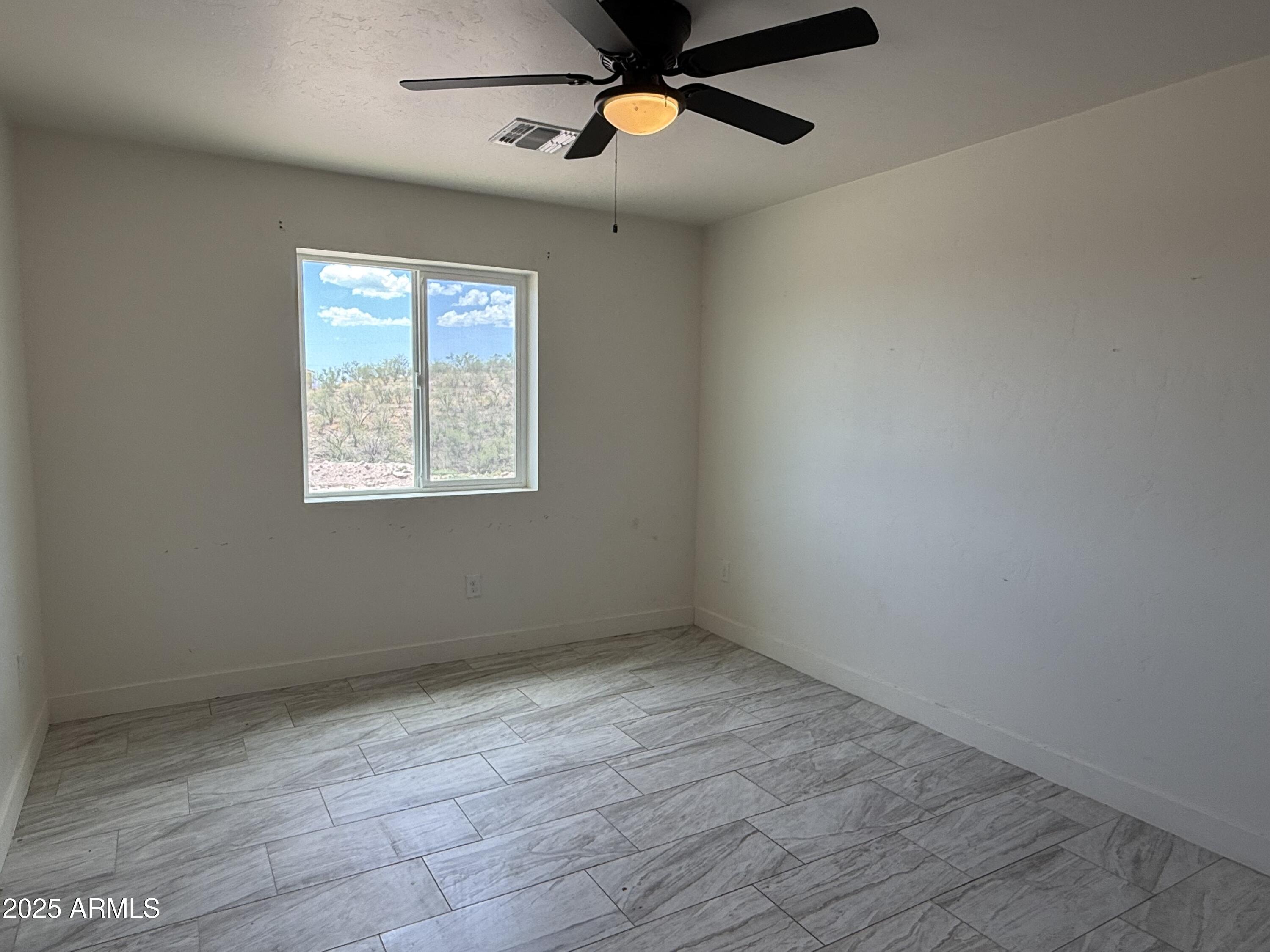 286 Guaymas Court Rio Rico, AZ 85648 - Photo 14 of 16 wooden floor in an empty room with a window