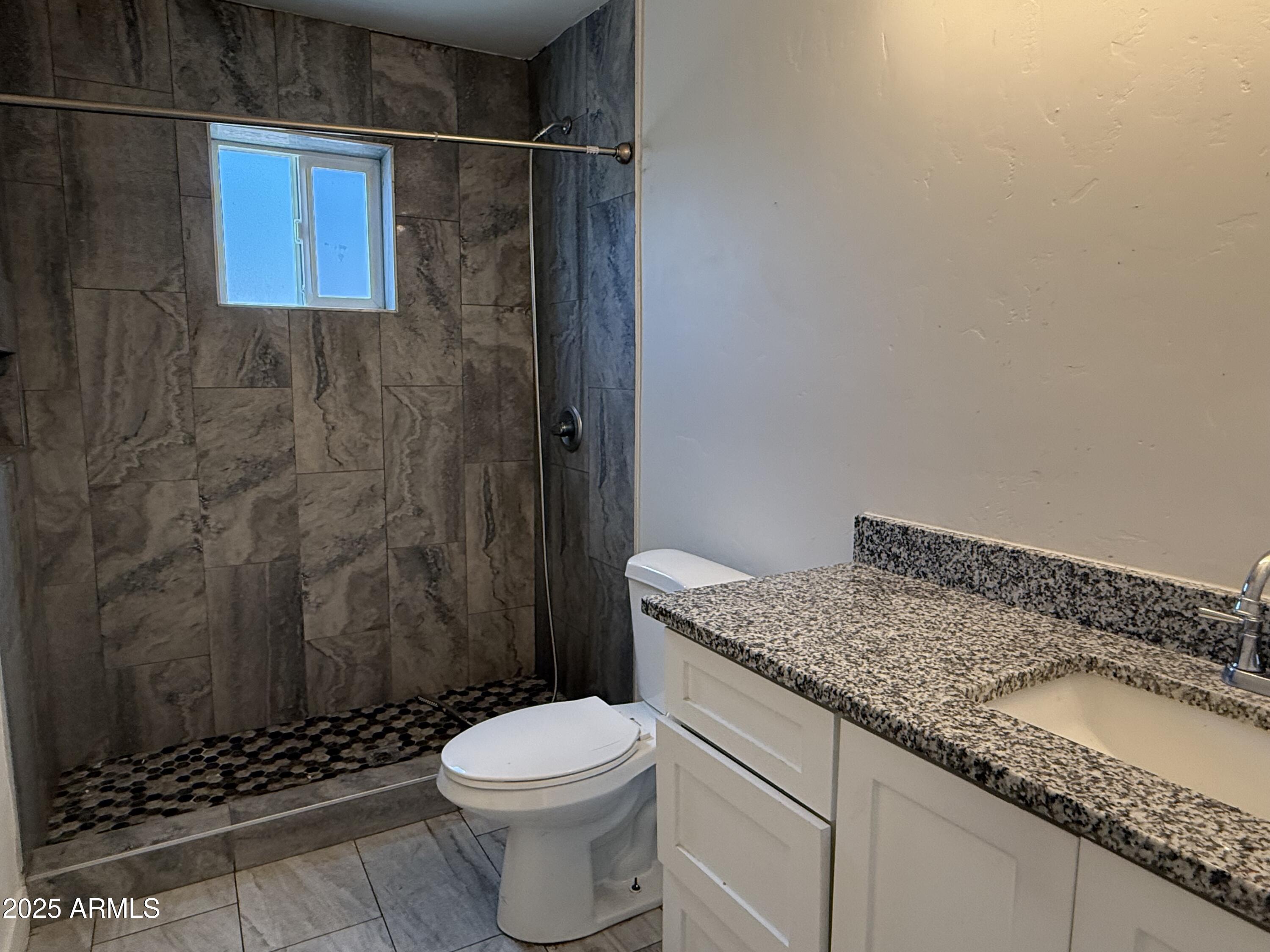 286 Guaymas Court Rio Rico, AZ 85648 - Photo 15 of 16 a bathroom with a granite countertop sink toilet and shower