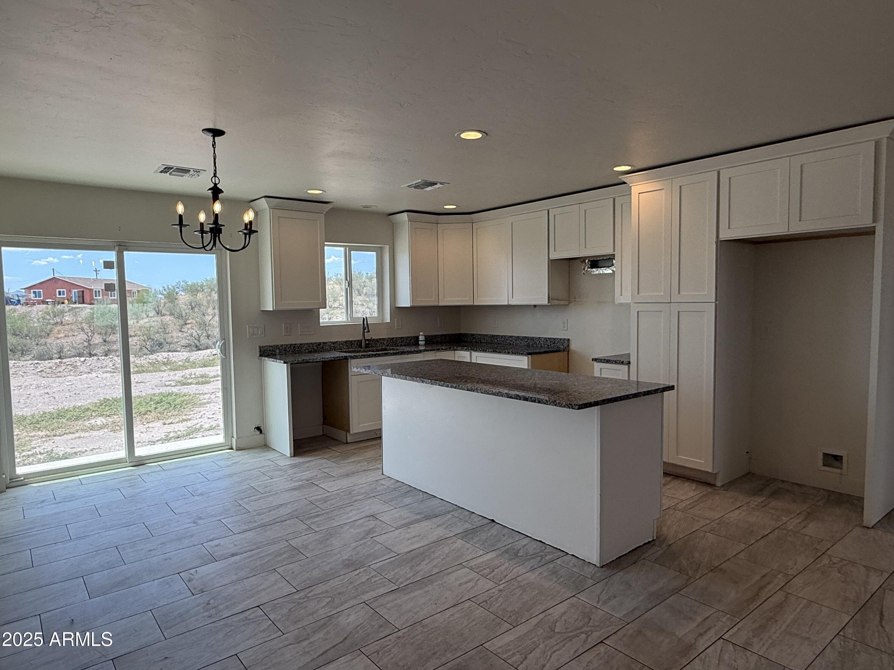 286 Guaymas Court Rio Rico, AZ 85648 - Photo 2 of 16 a kitchen with granite countertop a refrigerator and a stove top oven