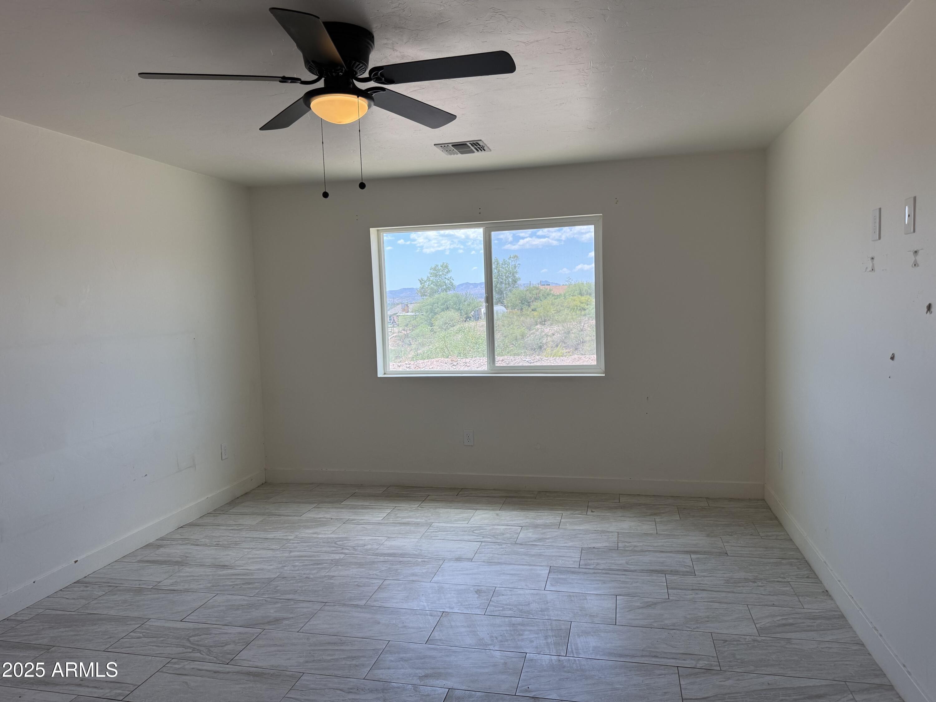 286 Guaymas Court Rio Rico, AZ 85648 - Photo 7 of 16 an empty room with a window and a fan