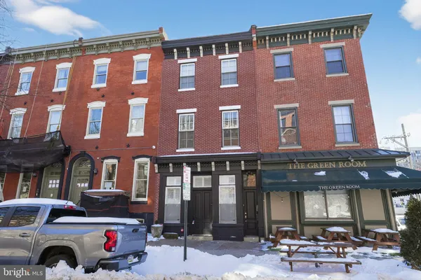 a front view of a building with outdoor seating