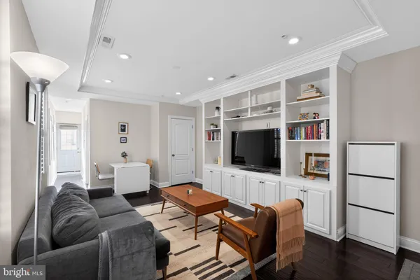 a living room with furniture flat screen tv and wooden floor