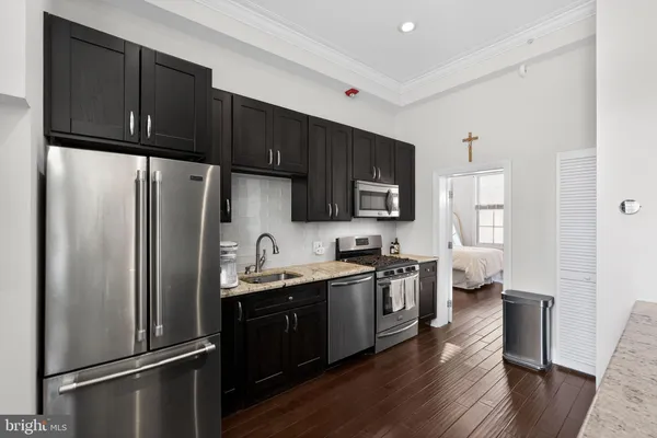 a kitchen with stainless steel appliances a refrigerator stove microwave and sink