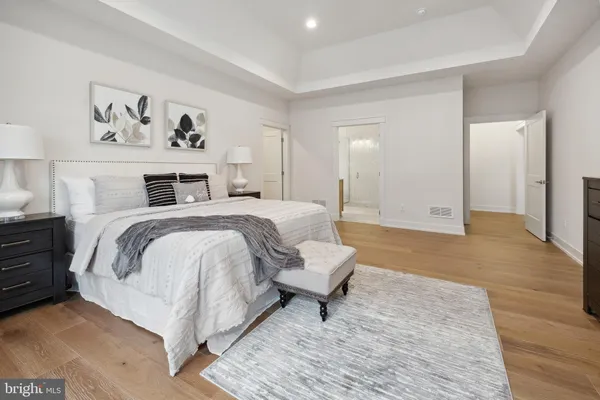 a spacious bedroom with a bed and painting on the wall