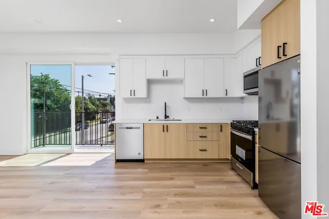 a kitchen with white cabinets and stainless steel appliances