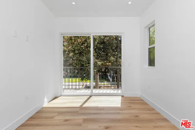 a view of a room with wooden floor and white doors