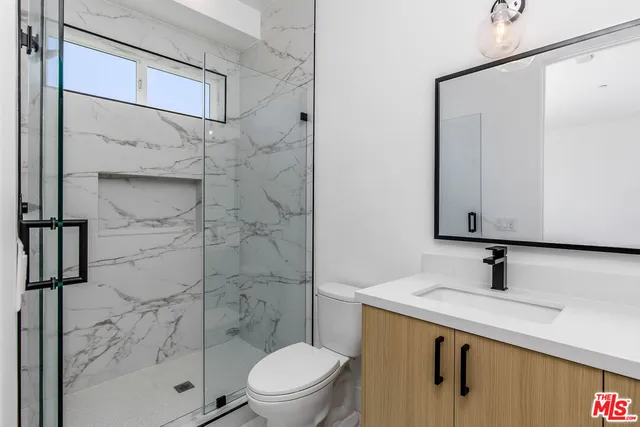 a view of an empty room with wooden floor and entryway