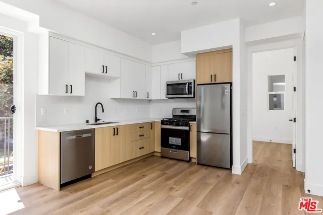 a view of a hallway with wooden floor and entryway