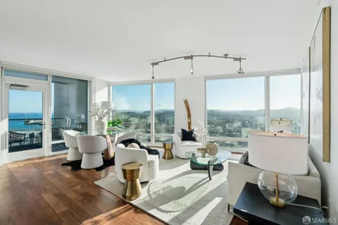 a living room with furniture and floor to ceiling windows