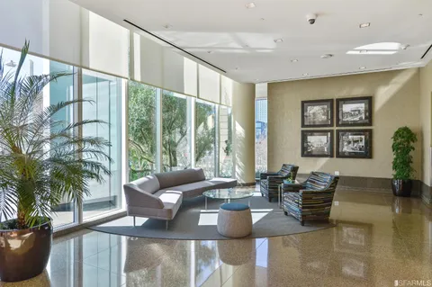 a living room with furniture and floor to ceiling windows