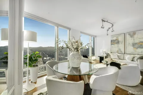 a dining room with furniture and a potted plant