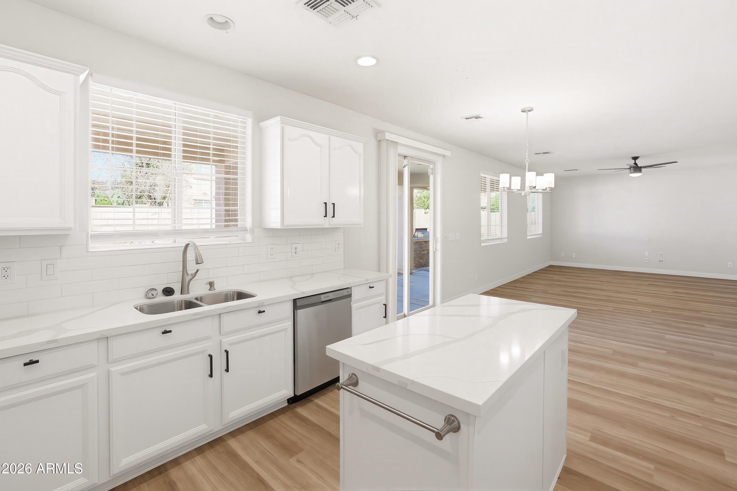 17328 West Bajada Road Surprise, AZ 85387 - Photo 6 of 40 a kitchen with a sink dishwasher and white cabinets with wooden floor