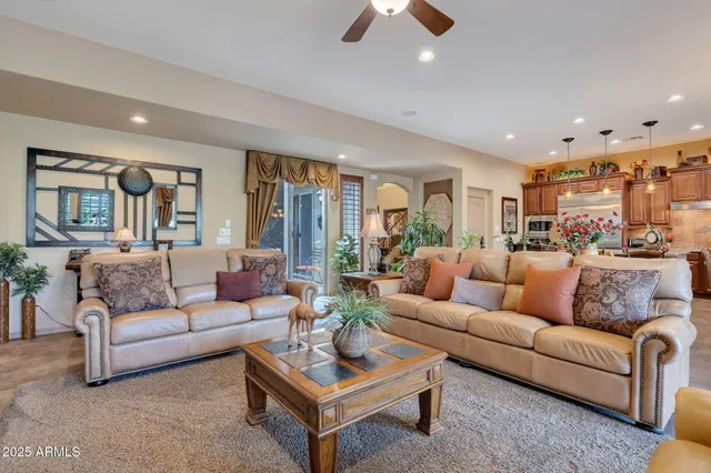 a living room with furniture kitchen view and a large window