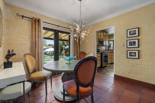 a dining room with furniture a chandelier and wooden floor