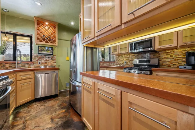 a kitchen with stainless steel appliances granite countertop a stove and cabinets