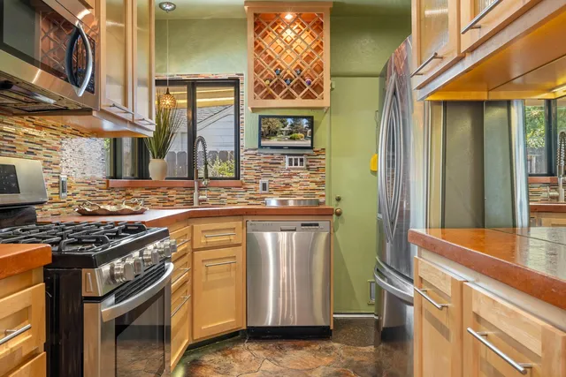 a kitchen with stainless steel appliances granite countertop a stove and a sink
