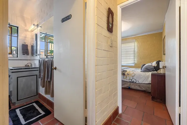 a view of a bedroom with a bed and wooden floor