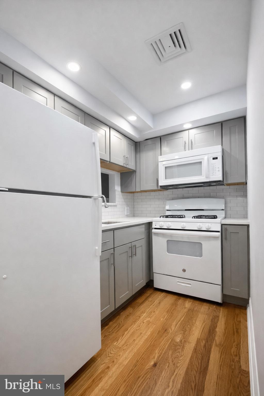 1701-03 Spruce Street, Unit 3R Philadelphia, PA 19103 - Photo 4 of 6 a kitchen with a white stove refrigerator and cabinets