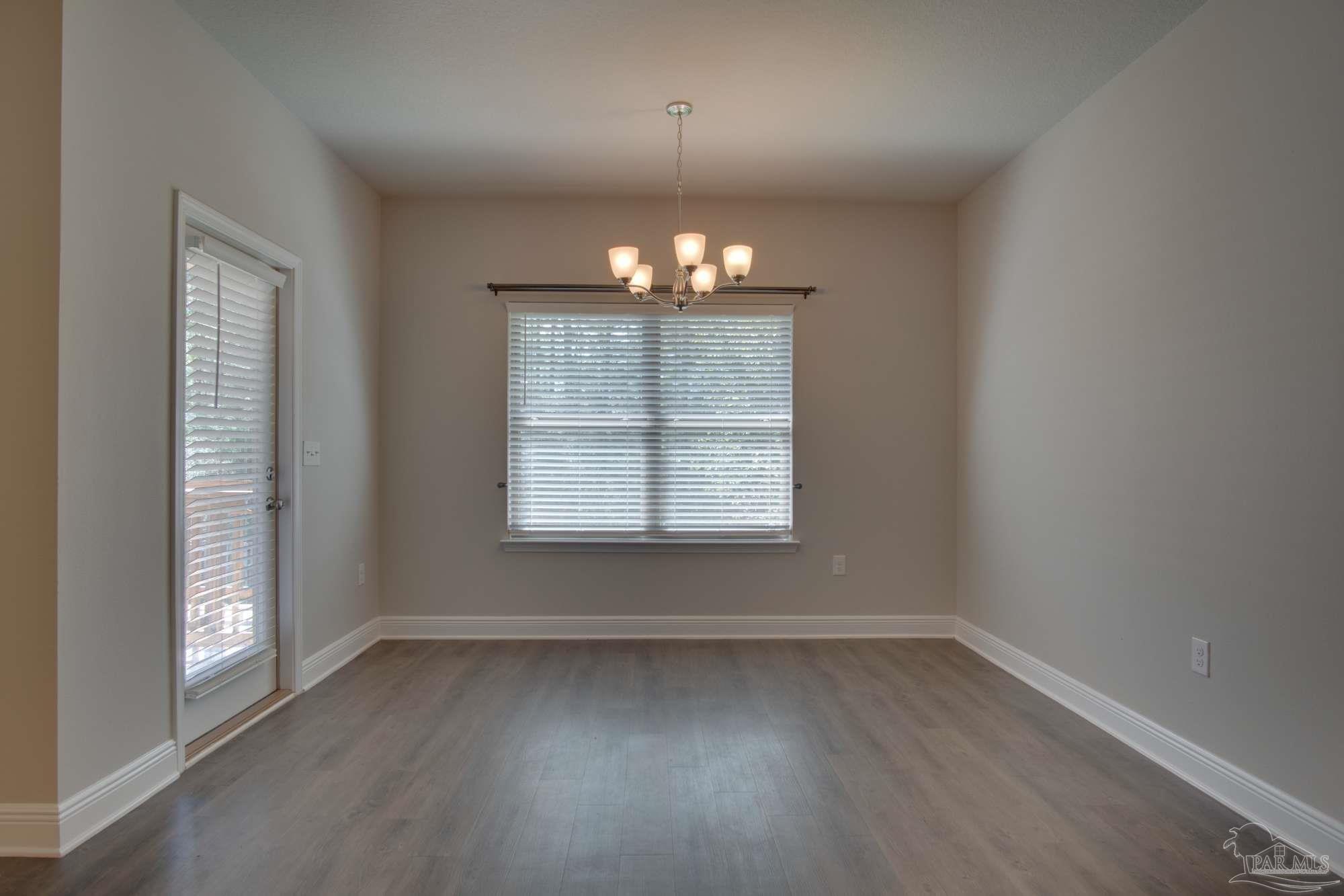 6239 Ladera Trail Pace, FL 32571 - Photo 16 of 27 an empty room with wooden floor and windows