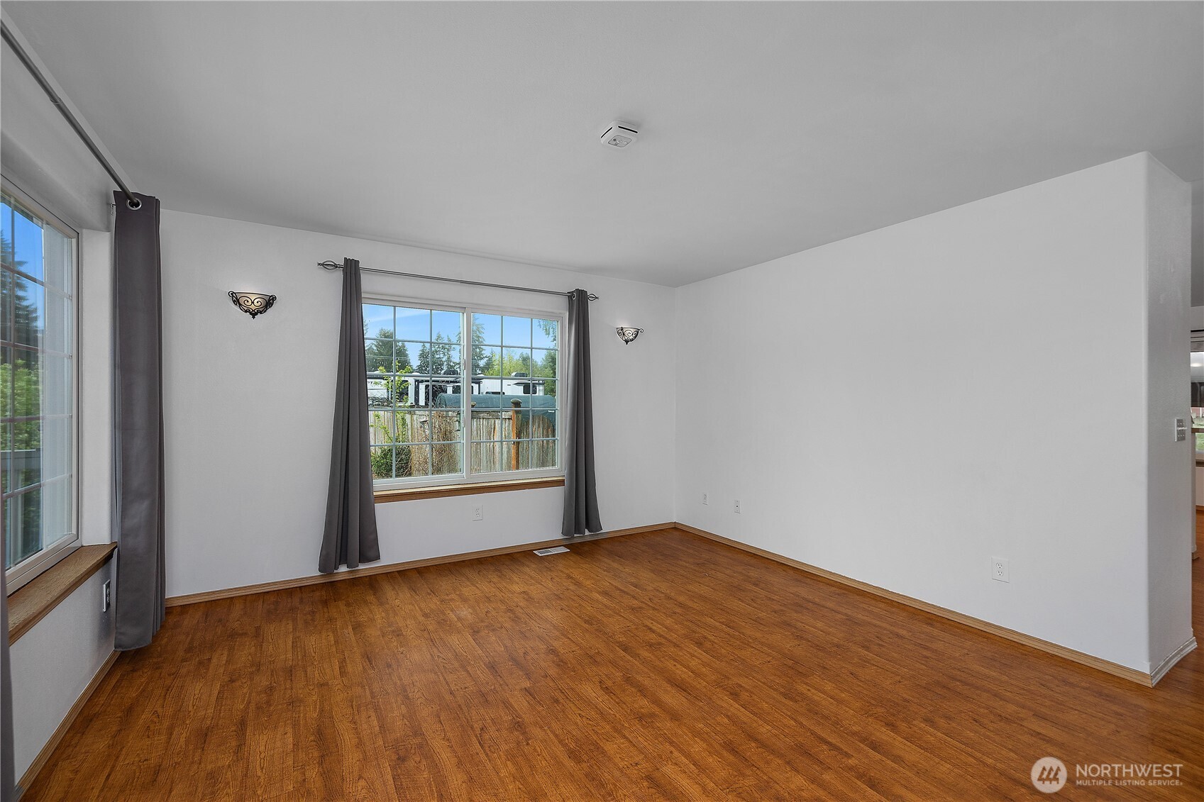 7606 187th Avenue Southwest Rochester, WA 98579 - Photo 5 of 28 a view of an empty room with wooden floor and a window