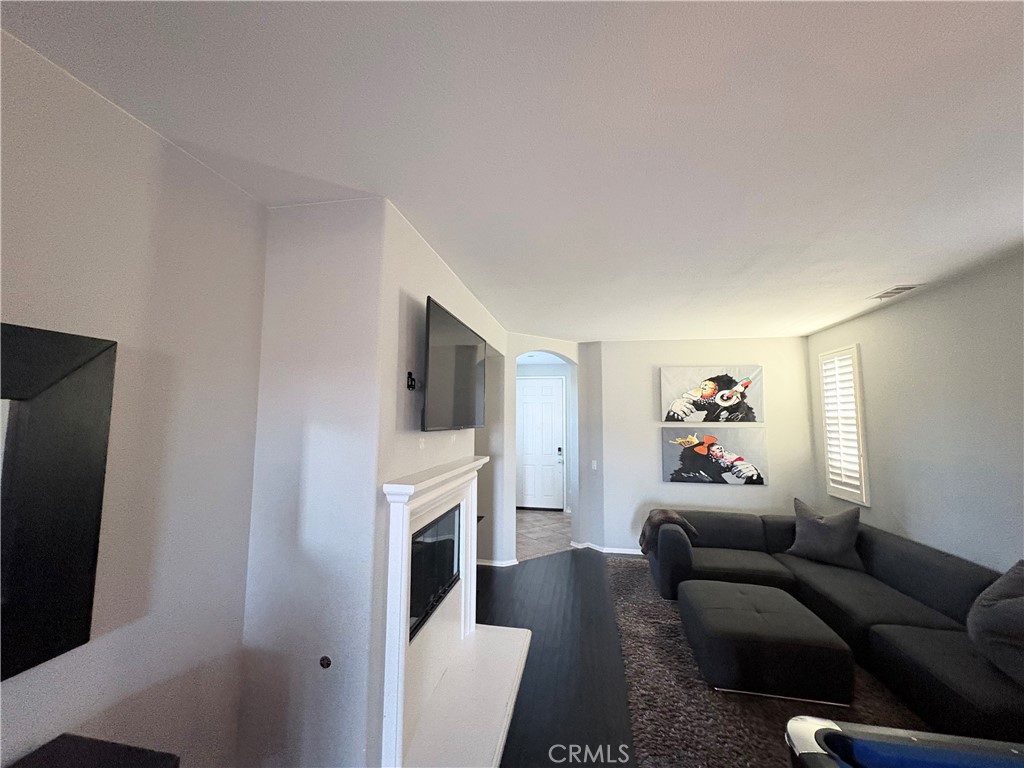 2729 Hornbeam Road Palmdale, CA 93551 - Photo 25 of 35 a living room with furniture a fireplace and a flat screen tv