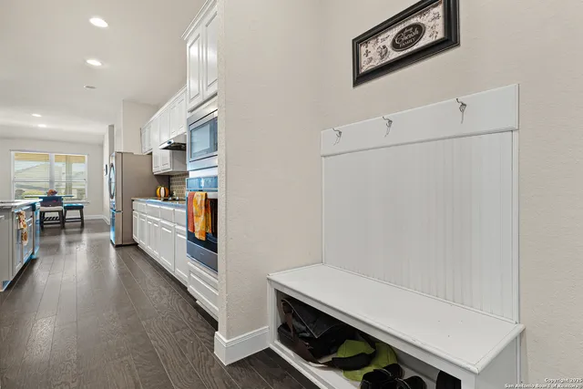 a kitchen with stainless steel appliances white cabinets and wooden floor