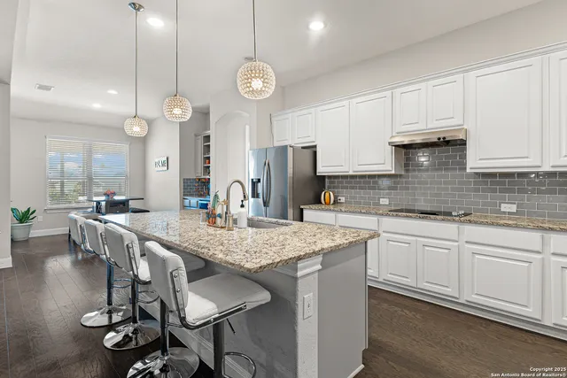a kitchen with center island table and chairs