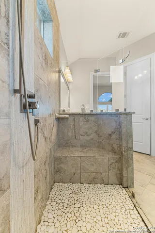 a bathroom with a granite countertop shower