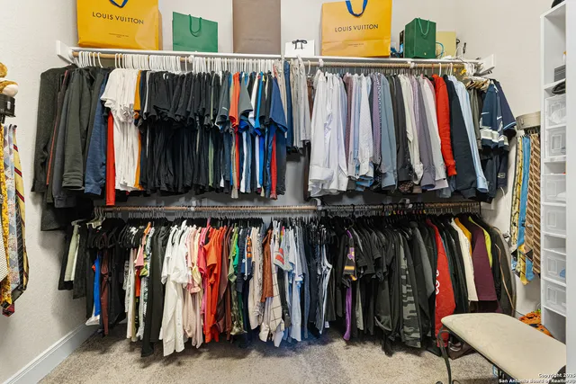 a view of walk in closet with clothes