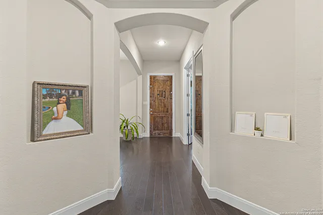 a view of a hallway with wooden floor and a potted plant