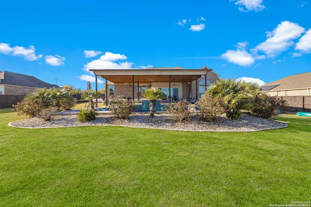 a view of a house with backyard and sitting area