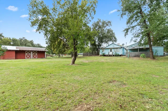 a view of a house with a yard and tree